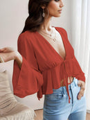 Blusa curta elegante e feminina com decote em V profundo e manga trombeta